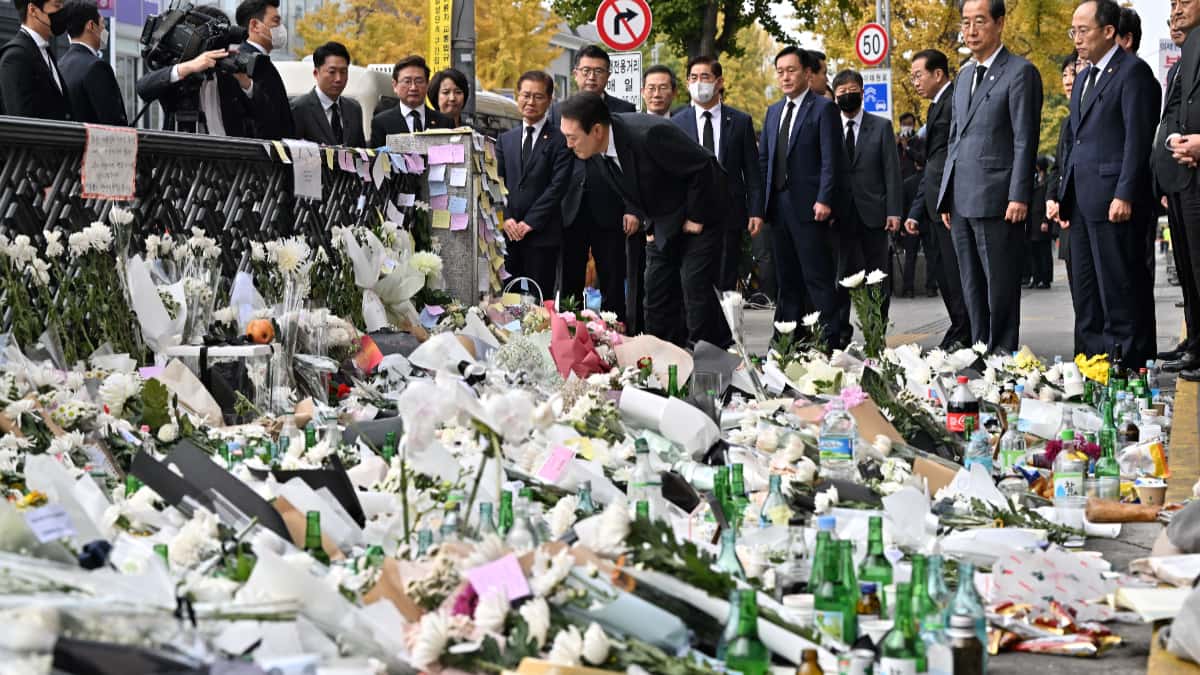 El presidente de Corea del Sur, Yoon Suk-yeol, mira los mensajes de los dolientes en un memorial improvisado para las víctimas de la tragedia.