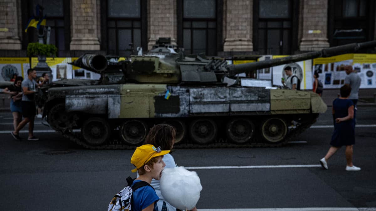 Un niño come junto a un equipo militar ruso destruido en la calle Khreshchatyk, en Kiev.