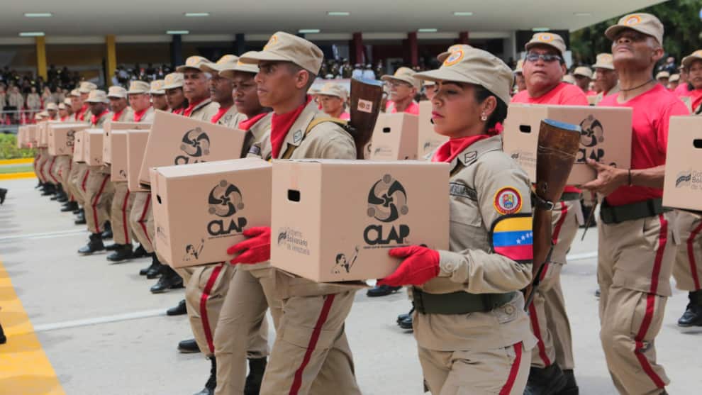 Miembros de la milicia venezolana llevan las cajas de alimentos conocidas como CLAP. Foto: AFP