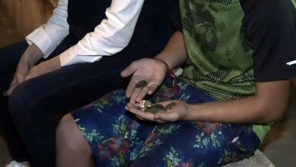 un niño sostiene las monedas que ganó trabajando solo en un semáforo de Montería. NoticiasRCN.com