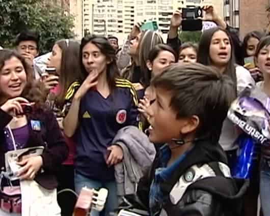Joven interpreta canciones de Justin Bieber a las afueras de un hotel en Bogotá.