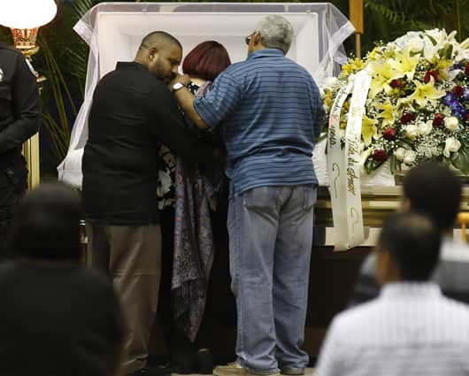 La familia de 'Cheo' Feliciano junto al cuerpo del fallecido artista. Foto: EFE