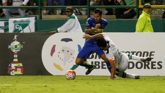 El jugador del Boca Juniors Carlos Tévez (i) protege el balón ante la marca de Andrés Pérez (d), del Cali. Foto Agencia EFE