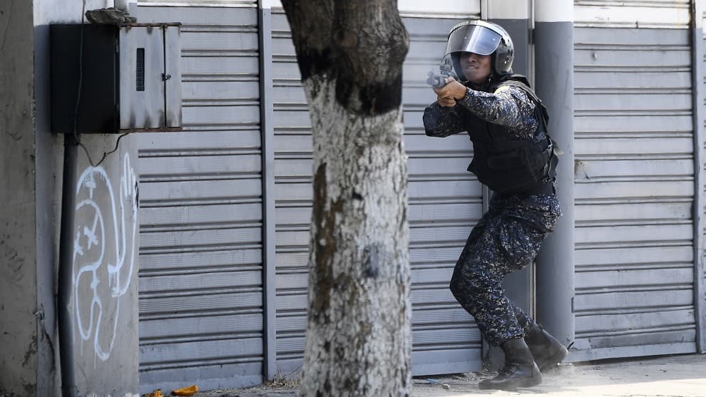 FOTO: Uniformado dispara en las calles de Caracas. AFP