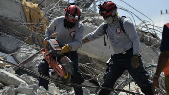 Una persona asegura en los alrededores de los escombros que aún falta su padre. Foto: AFP