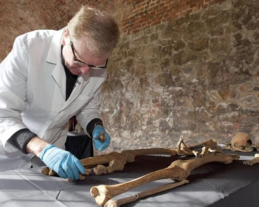 El osteólogo Don Walker junto a uno de los esqueletos encontrados en Londres. Foto: EFE.