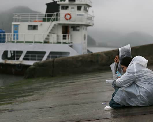 Familiares de los desaparecidos esperan en la costa para conocer noticias de sus seres queridos. Foto: EFE
