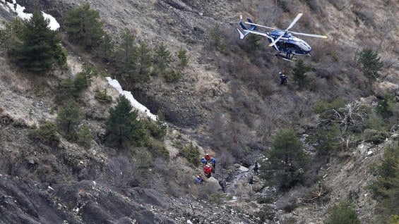 Unos miembros de los servicios de rescate llegan en helicóptero al área de alta montaña donde se estrelló un avión en los Alpes franceses. Foto. EFE
