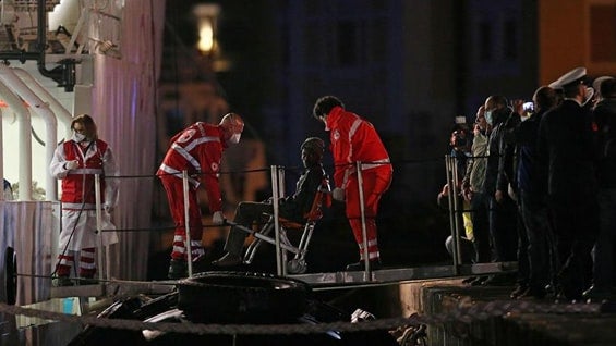 Miembros de la guardia costera italiana descienden con un sobreviviente de un naufragio al barco guardacostas Bruno Gregoretti en el puerto de Catania. Foto: EFE.
