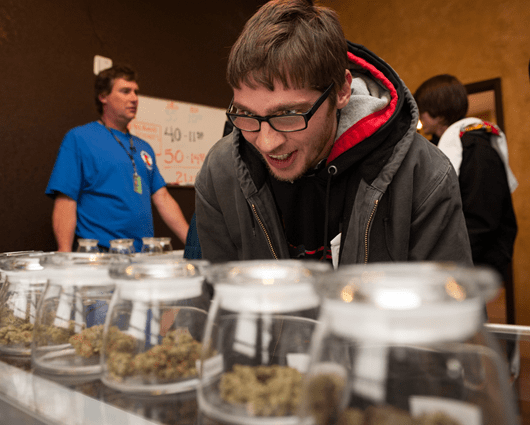 Cliente observa las diferentes presentaciones que se ofrecen de la marihuana. Foto: AFP.