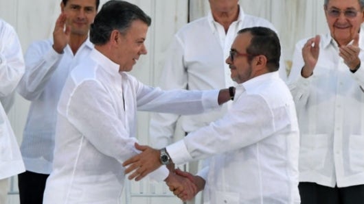 Santos y 'Timochenko' el día que firmaron la paz. Foto: AFP