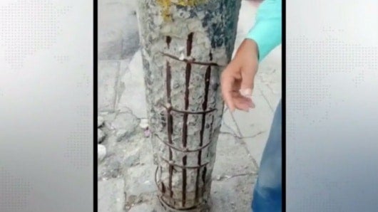 El poste está al lado de una vivienda.