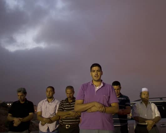 Palestinos rezan mientras esperan la llegada de los presos liberados. Foto: AFP