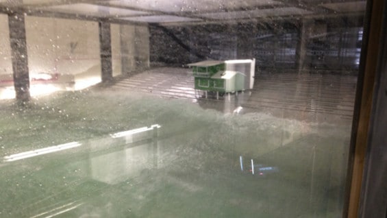 Dentro del tanque, una casa verde y blanca recibe la fuerza del ciclón. Foto: AFP.