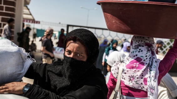 Mujeres sirias cruzando la frontera con Turquía. Foto: AFP