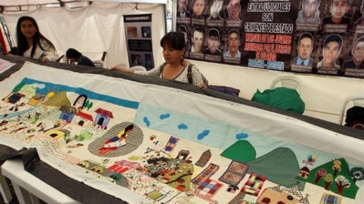 Mujeres víctimas de la violencia y participantes tejen un tapete de más de 400 metros. Foto Agencia EFE