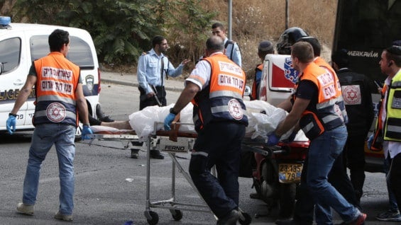 Atención médica en el lugar donde dos hombres atacaron a los pasajeros de un bus. Foto: AFP