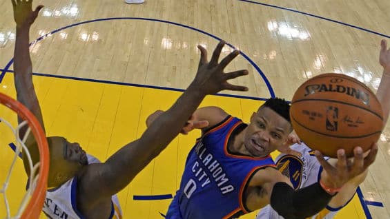 Russell Westbrook (c) de Oklahoma City Thunder salta para encestar sobre Draymond Green (i) de Golden State Warriors. Foto Agencia EFE