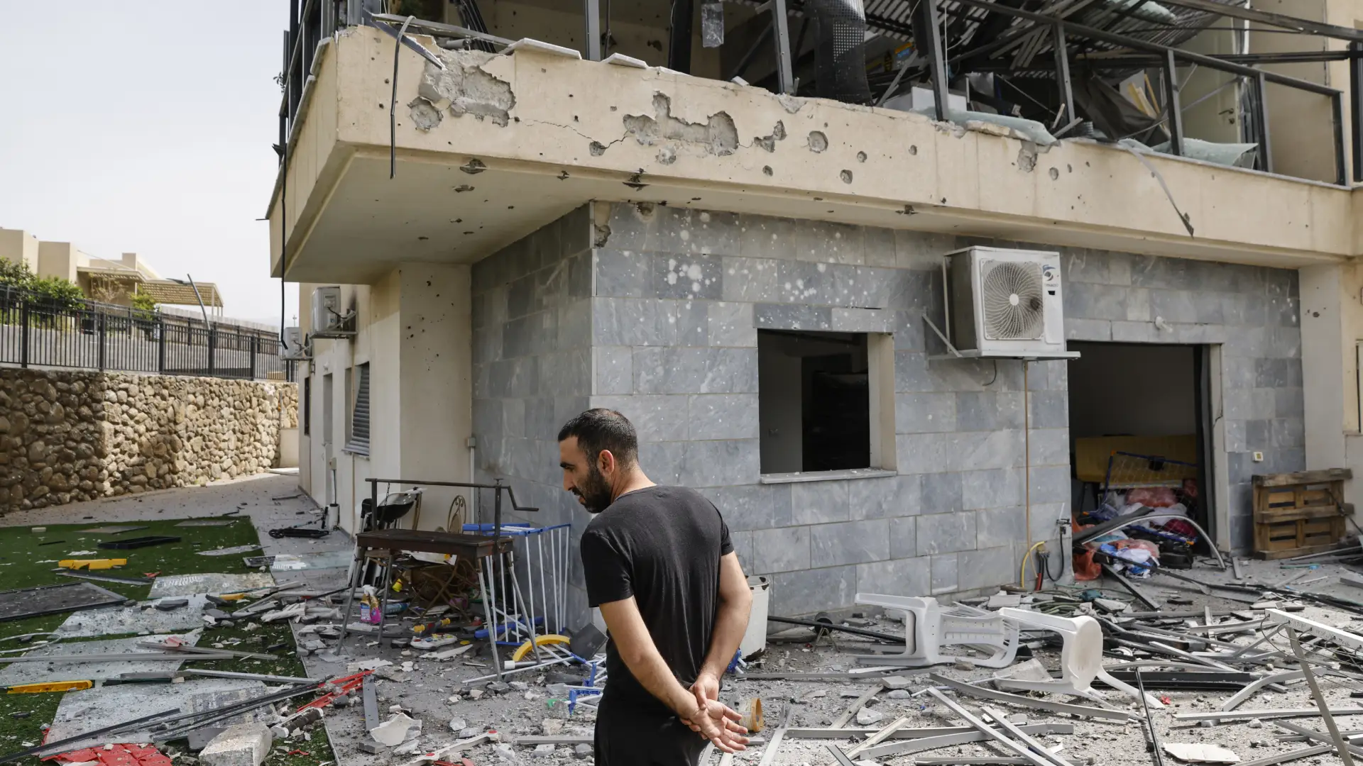 Un israelí revisa una casa que fue alcanzada por un cohete de Hezbollah en Kiryat Shmona, en el norte de Israel