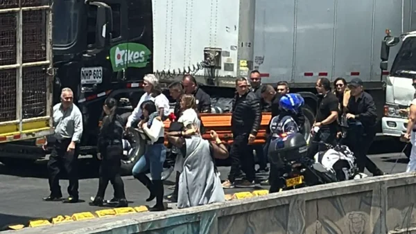 Familias caminan con ataúdes en medio de camiones para llegar al cementerio