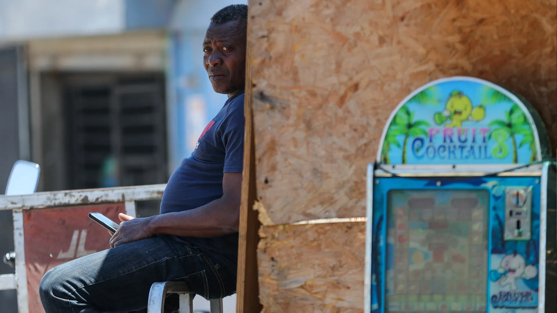 Un hombre se sienta sobre la baranda de un camión en el barrio “Un Nuevo Amanecer”, comuna de Cerrillos, Región Metropolitana de Santiago, el 11 de noviembre de 2025. Chile se prepara para acudir a las urnas el 16 de noviembre en medio de temores por la inseguridad, atribuida en gran medida a los migrantes en situación irregular, a pesar de que el país mantiene una de las tasas de criminalidad más bajas de la región. Mientras todos los candidatos centran sus campañas en la delincuencia y la migración, los aspirantes de derecha prometen hacer que los inmigrantes indocumentados se sientan no bienvenidos.