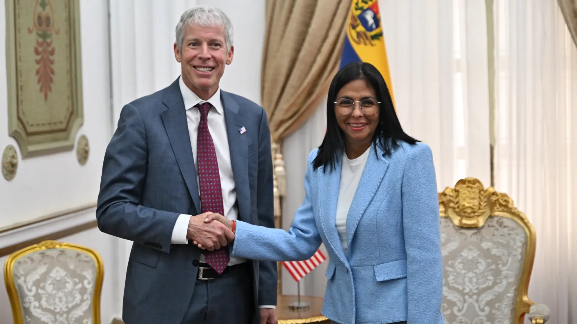 US Secretary of Energy Chris Wright (L) shakes hands with Venezuela's acting president Delcy Rodriguez